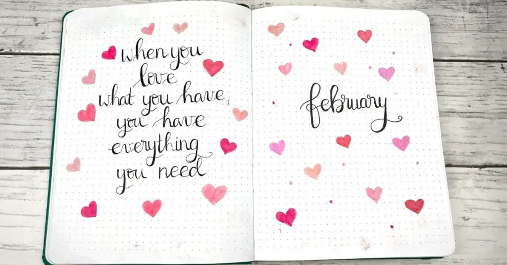 February 2022 Bullet Journal quote page and cover page filled with pink hearts