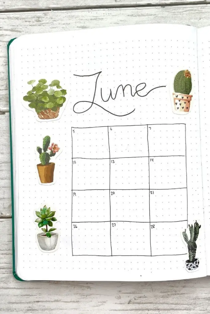 June bullet journal calendar spread with plant stickers