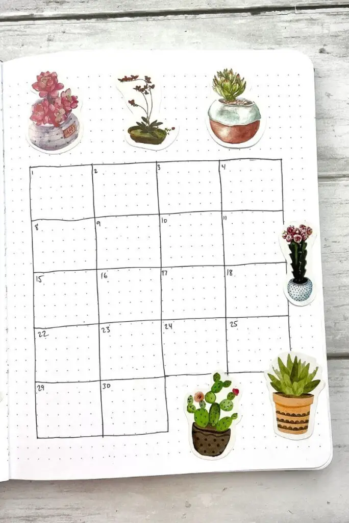 June bullet journal calendar spread with plant stickers